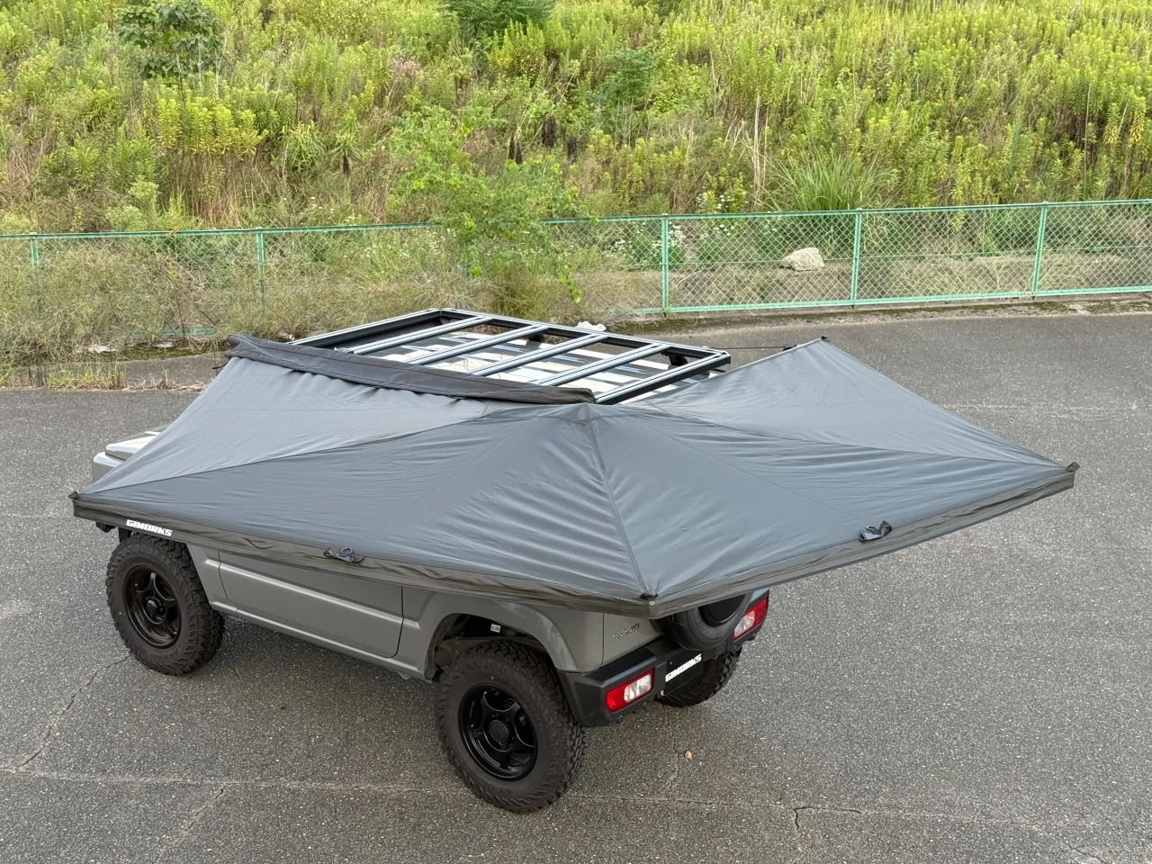 車のルーフに取り付けた灰色のLite 270度サイドオーニングを展開した様子