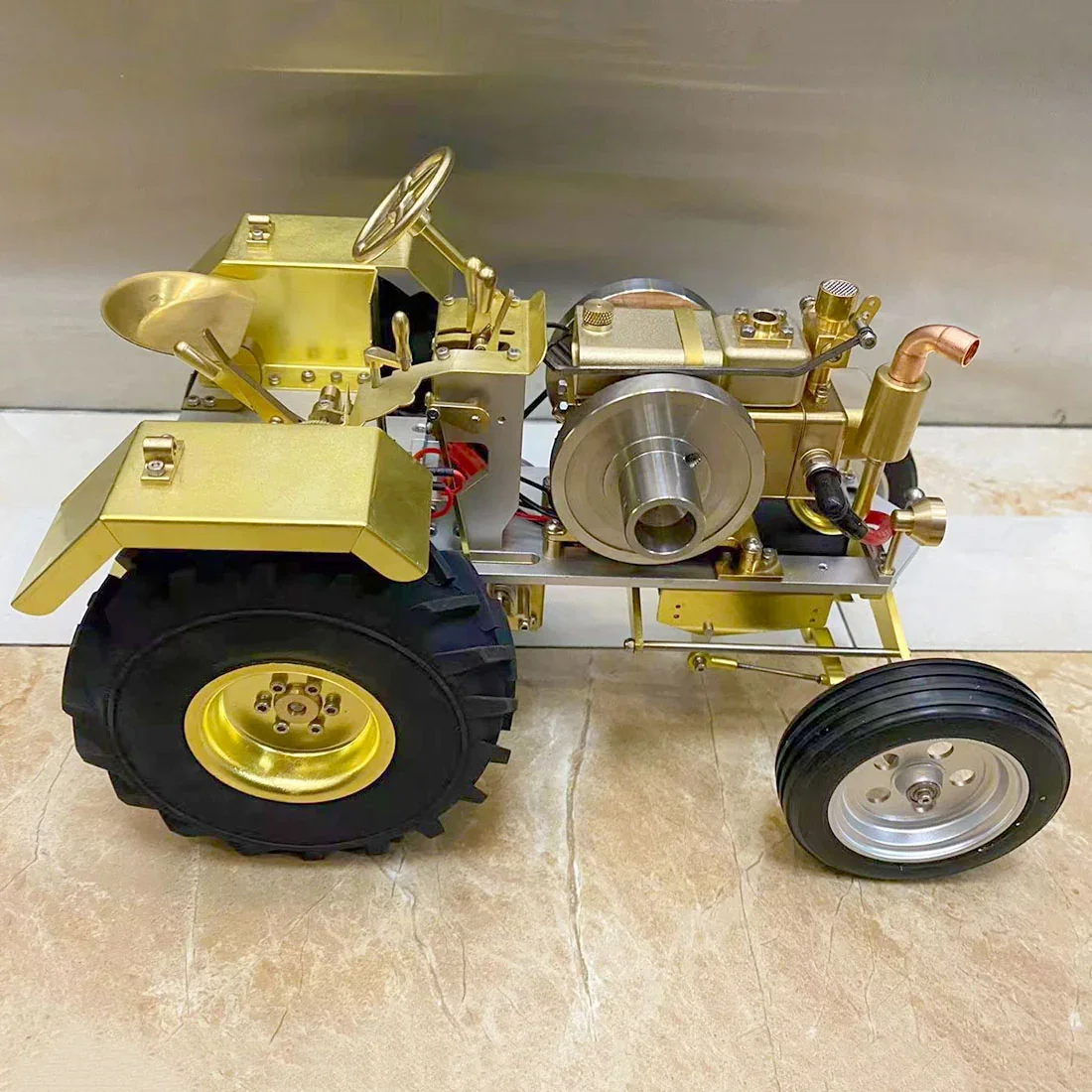 T12トラクター模型の側面。真鍮色の車体とフライホイール、銅色の管