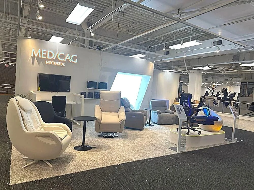 MEDICAG MYTREXの展示ブース。白いチェアやソファが並ぶ