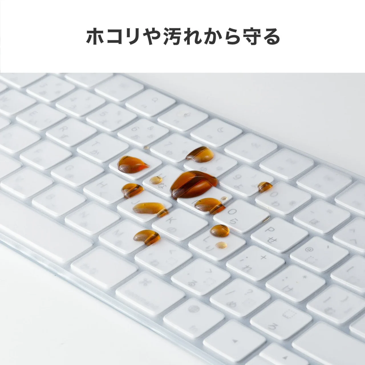 ホコリや汚れから守る透明カバー付きキーボードに茶色い液体がこぼれた様子