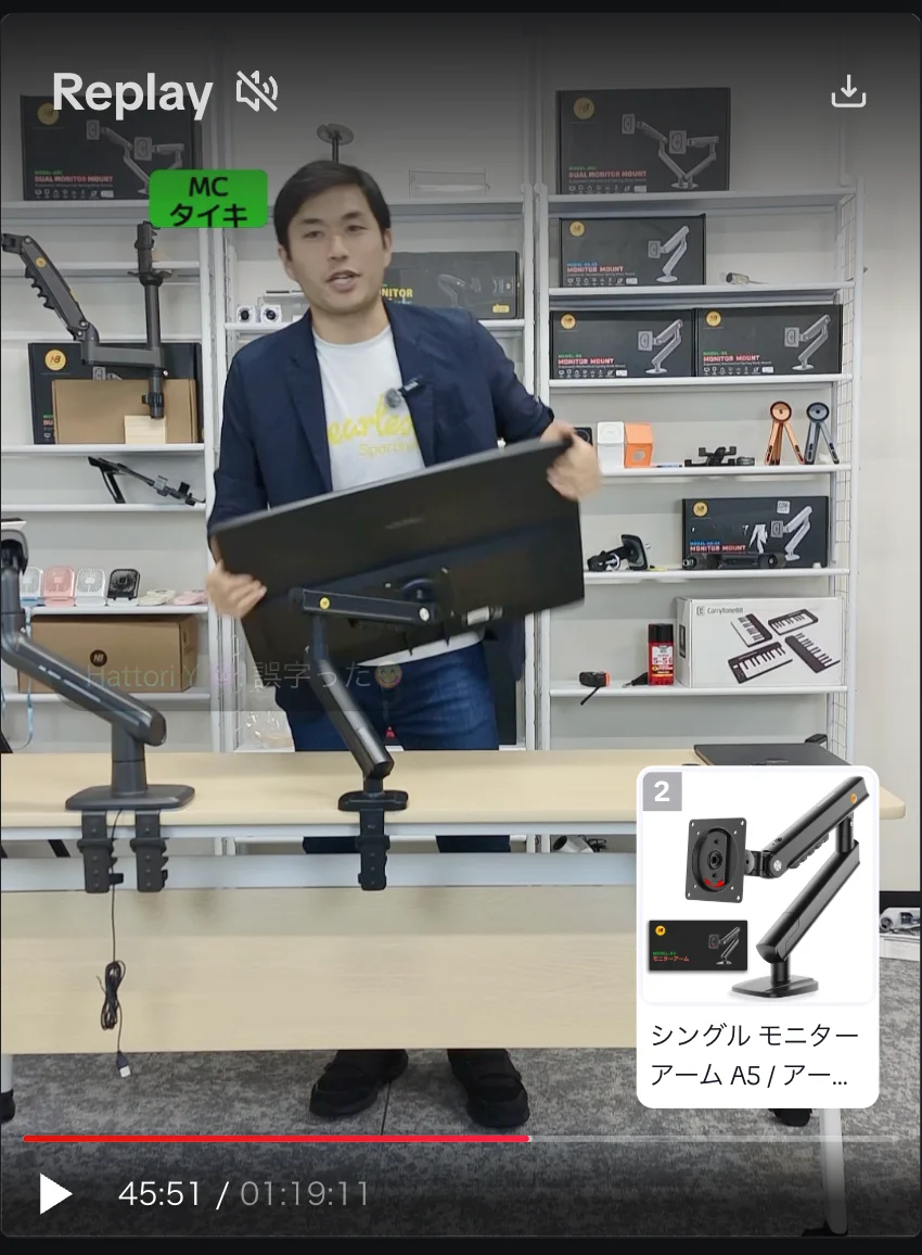 TikTokライブ配信画面イメージ。男性がモニターアームにモニターを取り付ける様子