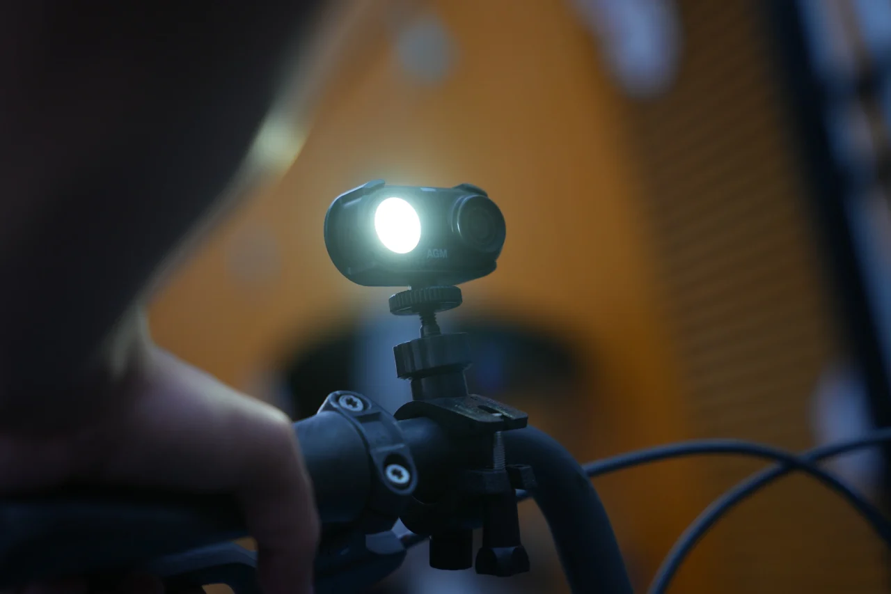 自転車のハンドルに取り付けたAGM CAM 1と点灯する補助ライト