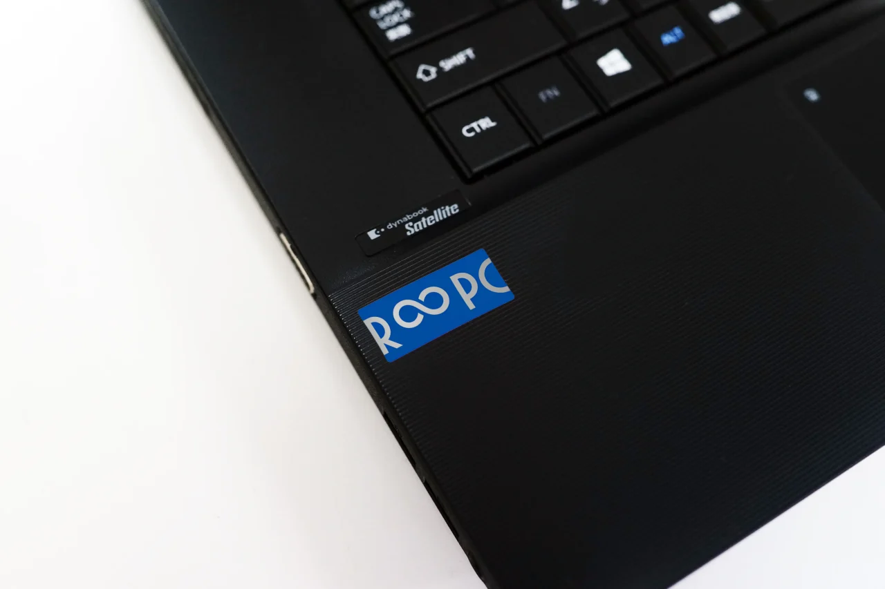 黒いノートPCの本体に貼られたR∞PCの青ステッカー