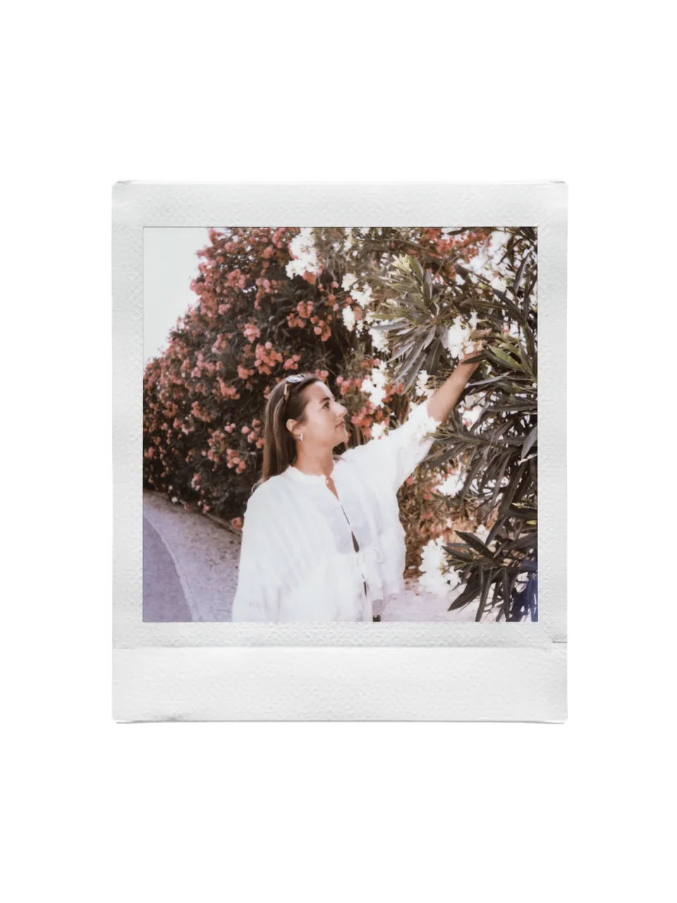 instax SQUARE フィルム「SOFT HAZE」の作例、花の木に手を伸ばす白い服の人物