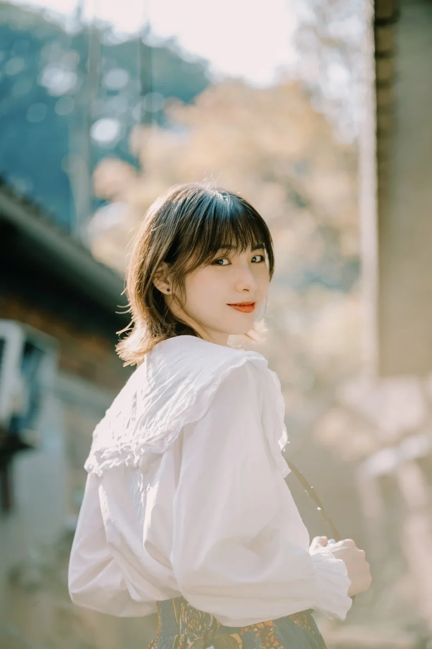 サンプルフォト:白いブラウスの女性を背景ぼかしで撮影したポートレート