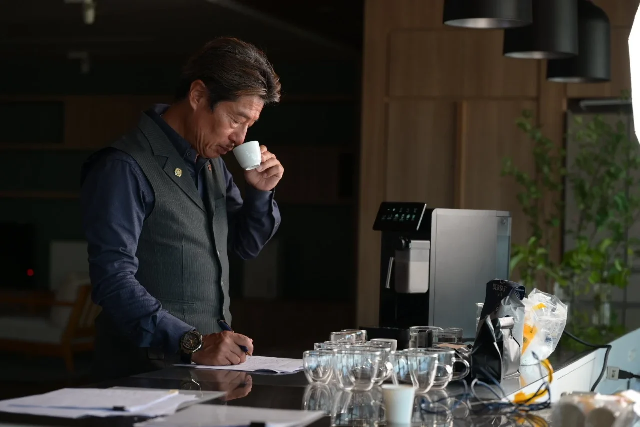 バリスタ・マエストロがエスプレッソを試飲しメモを取る様子
