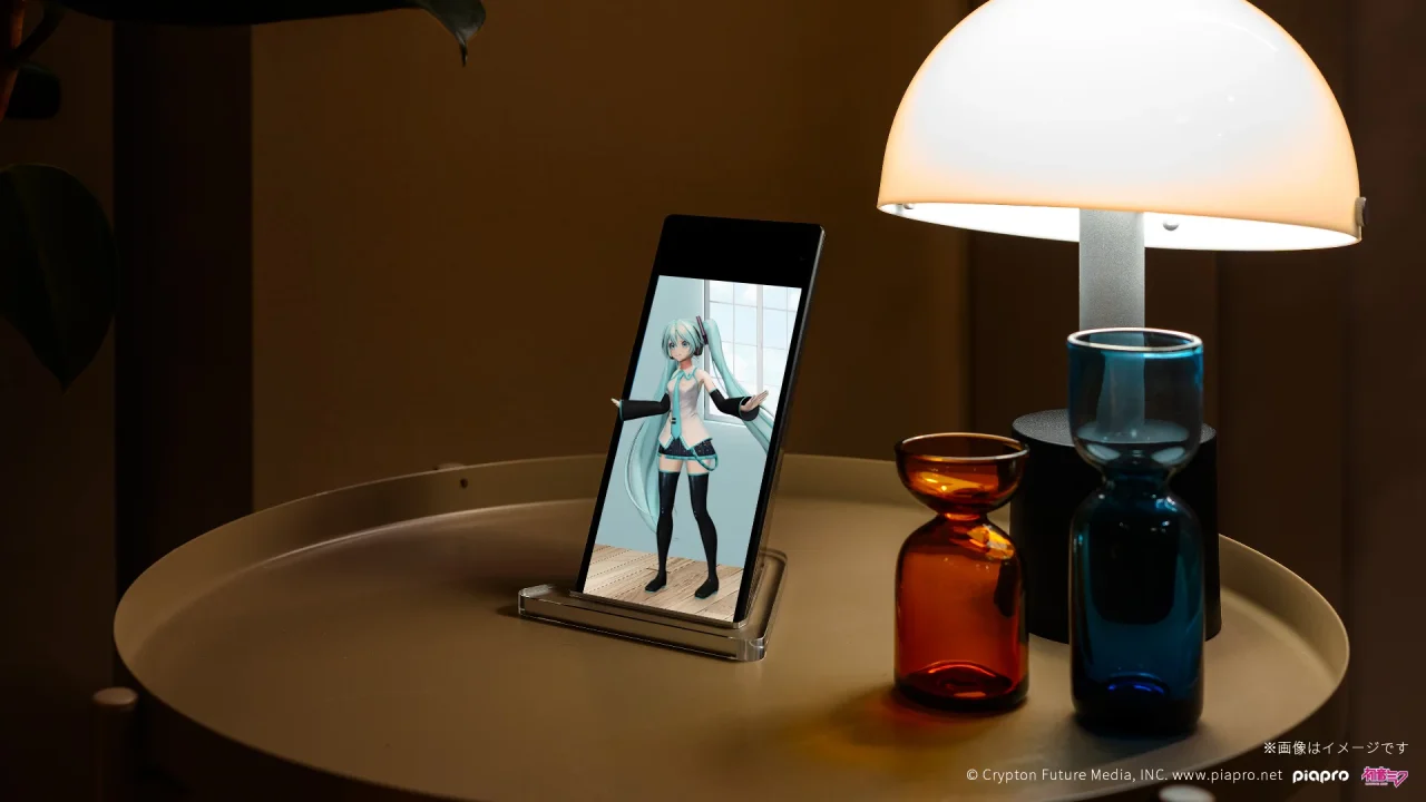 ホロモデルのキャラクターを表示した小型ディスプレイとランプの置かれたテーブル