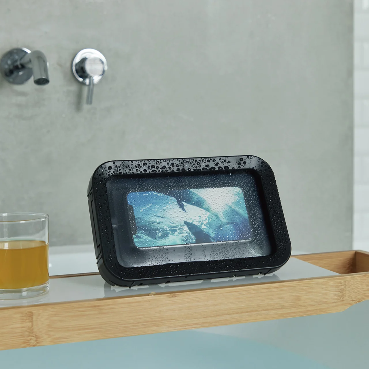 浴槽のフタの上にスタンドで置かれた、水滴の付いた防水ケースMAGCASE