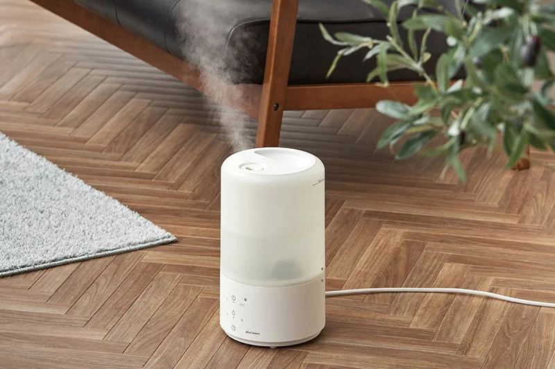 木目の床に置かれ、ミストを出す白い蒸気が熱くない上部給水スチーム加湿器