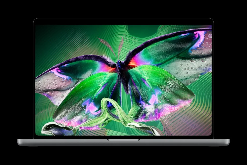 MacBook Proの画面に緑と紫の蝶のアートを表示した正面写真