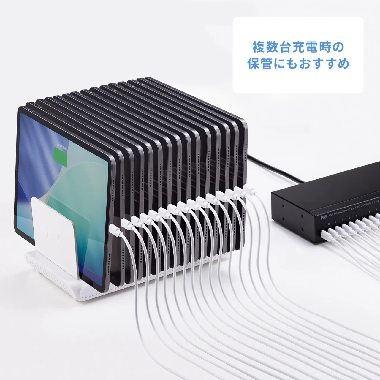 多数のタブレットを立てて収納し、白いケーブルで充電しているスタンド