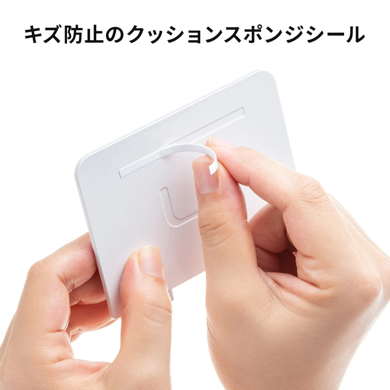 白い仕切り板にクッションスポンジシールを貼る手元